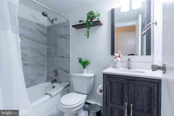 a bathroom with a granite countertop toilet sink and shower