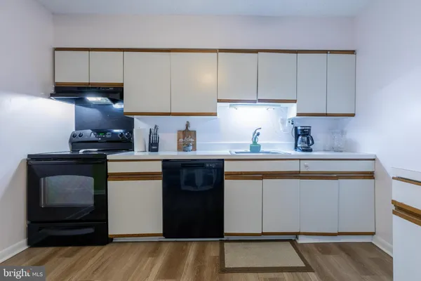 a kitchen with granite countertop a refrigerator sink and cabinets