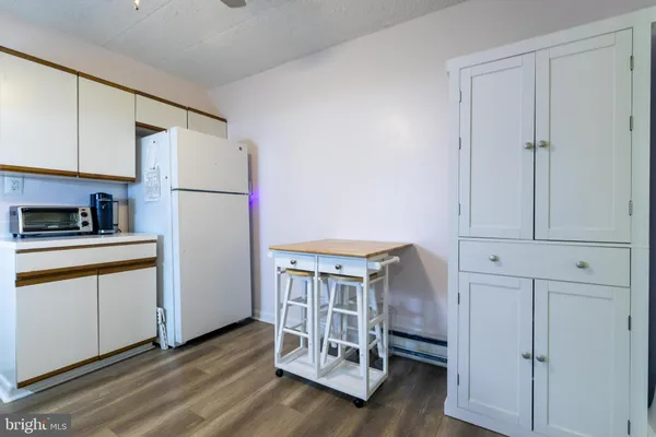 a kitchen with white cabinets and white appliances