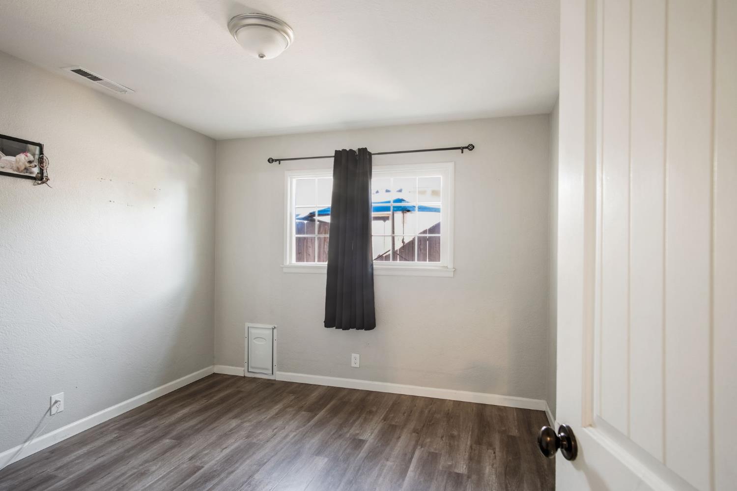 1725 Bronson Avenue Modesto, CA 95350 - Photo 12 of 17 an empty room with wooden floor and windows
