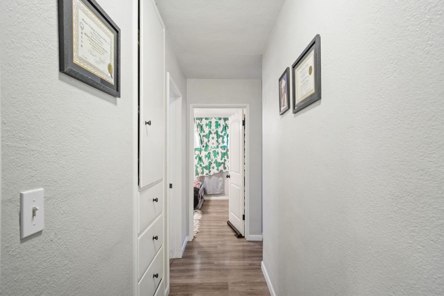 1725 Bronson Avenue Modesto, CA 95350 - Photo 13 of 17 a view of a hallway with wooden floor and a bathroom