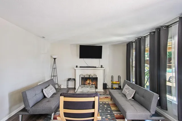a living room with furniture a fireplace and a flat screen tv