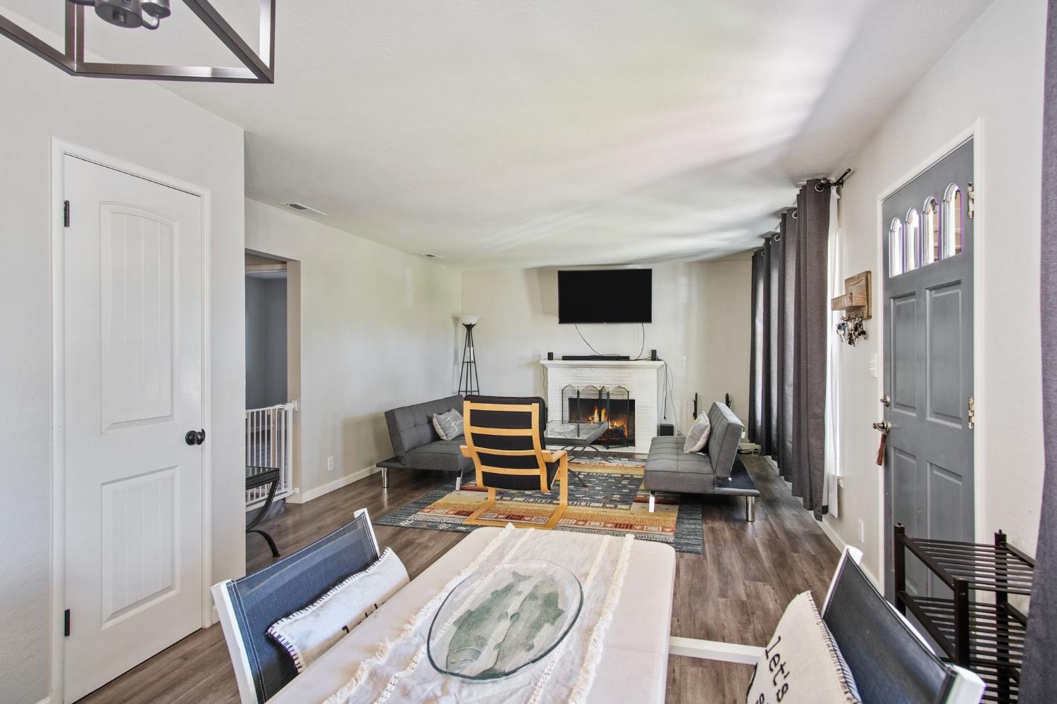 1725 Bronson Avenue Modesto, CA 95350 - Photo 6 of 17 a living room with furniture a fireplace and a flat screen tv