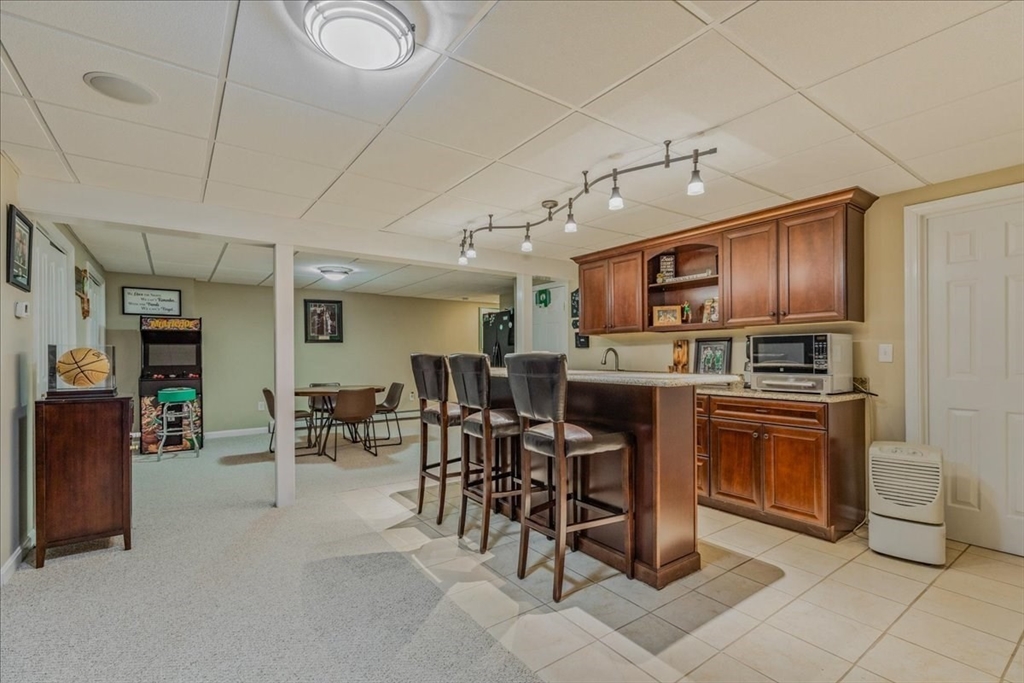 14 Robinson Road Rochester, MA 02770 - Photo 27 of 42 a kitchen with stainless steel appliances granite countertop a stove top oven a sink dishwasher a dining table and chairs with wooden floor