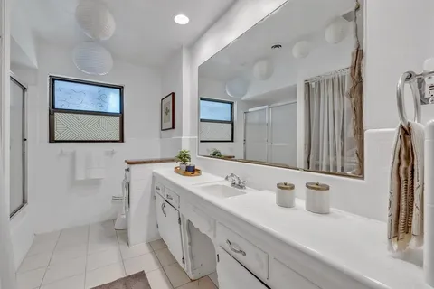 a bathroom with a double vanity sink mirror and bathtub