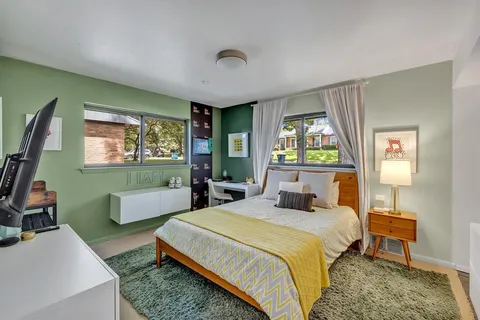 a bedroom with a bed and large windows