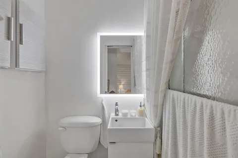 a bathroom with a toilet a sink and a window