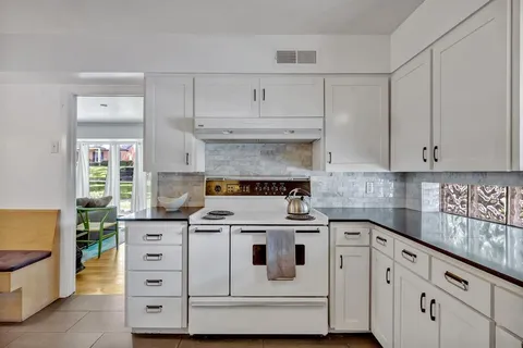a white stove top oven sitting inside of a kitchen