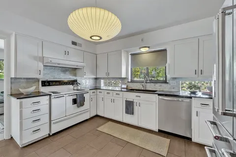 a kitchen with granite countertop white cabinets and white appliances