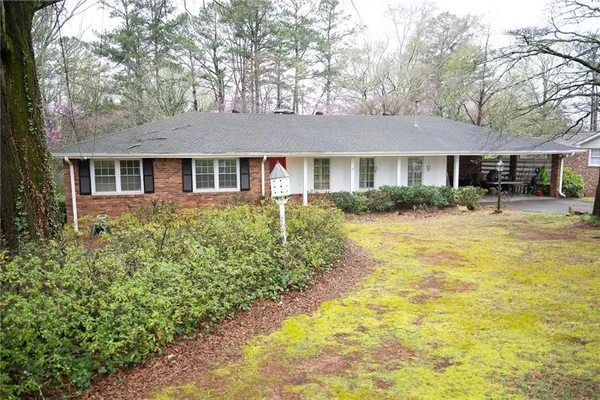 a front view of house with yard and trees around
