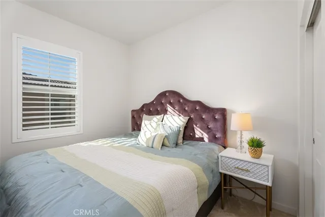 a bedroom with a bed table and a window