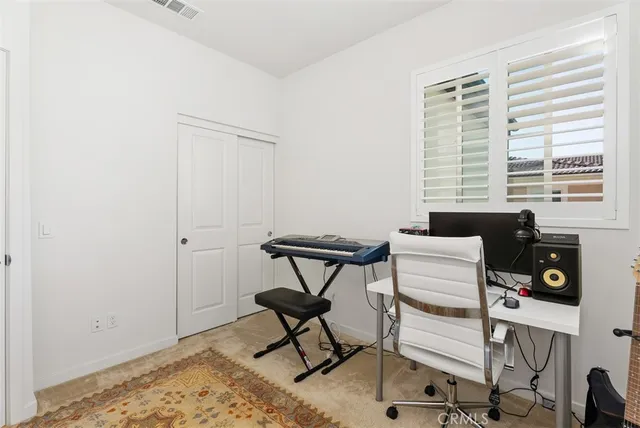 a view of a workspace with furniture and a window