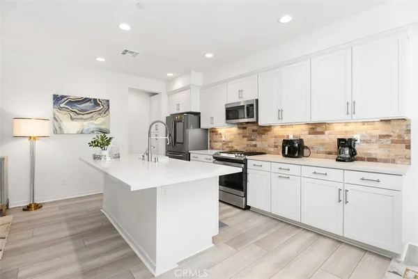 a kitchen with sink a microwave and cabinets