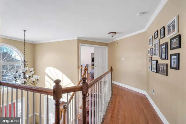 a view of a hallway with wooden floor and staircase