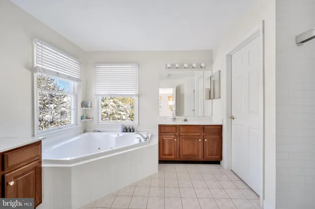 a large bathroom with a tub sink and mirror