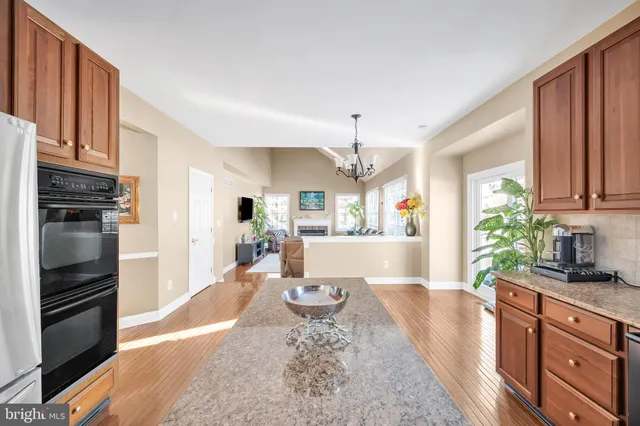 a large kitchen with kitchen island granite countertop a refrigerator stove top oven a sink and dishwasher