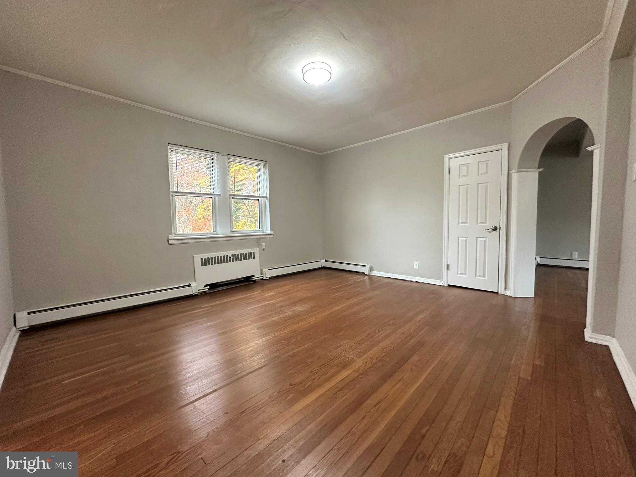 4927 Wynnefield Avenue, Unit 17A Philadelphia, PA 19131 - Photo 13 of 24 an empty room with wooden floor and windows