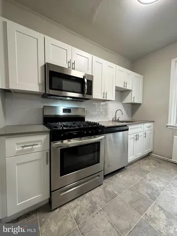 a kitchen with stainless steel appliances granite countertop a sink a stove a microwave and cabinets