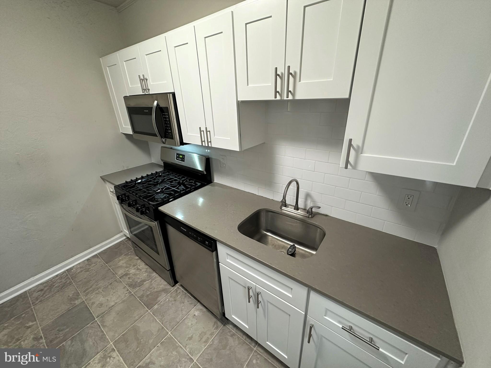 4927 Wynnefield Avenue, Unit 17A Philadelphia, PA 19131 - Photo 18 of 24 a kitchen with stainless steel appliances a sink a stove and cabinets