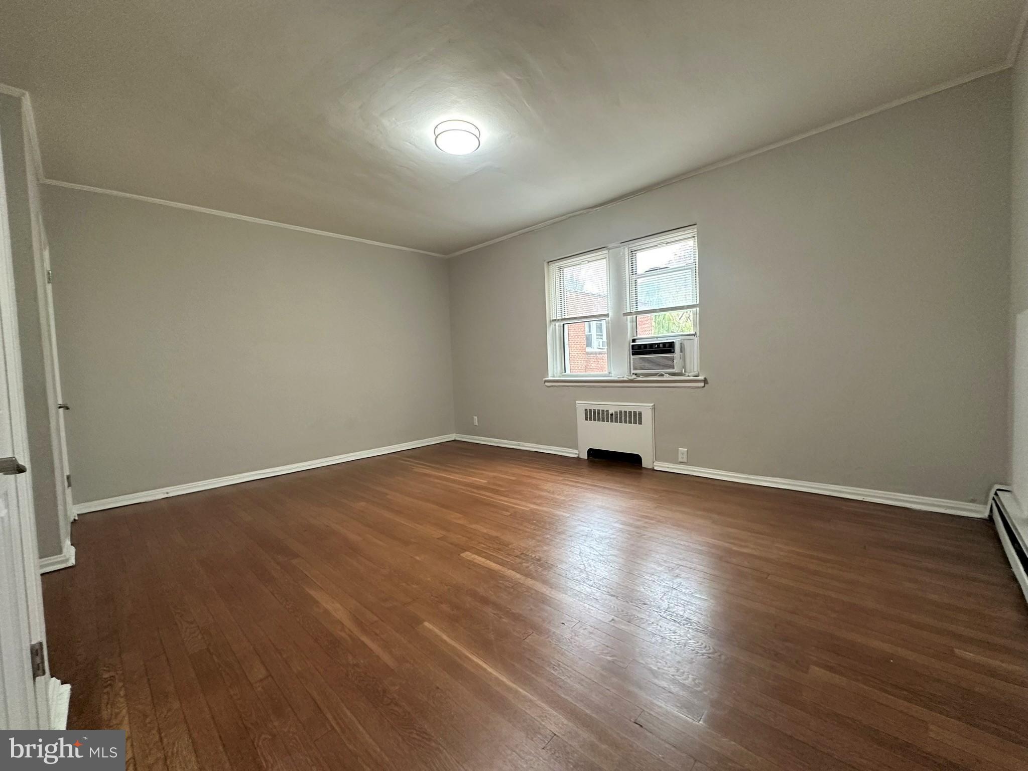 4927 Wynnefield Avenue, Unit 17A Philadelphia, PA 19131 - Photo 20 of 24 an empty room with wooden floor and windows
