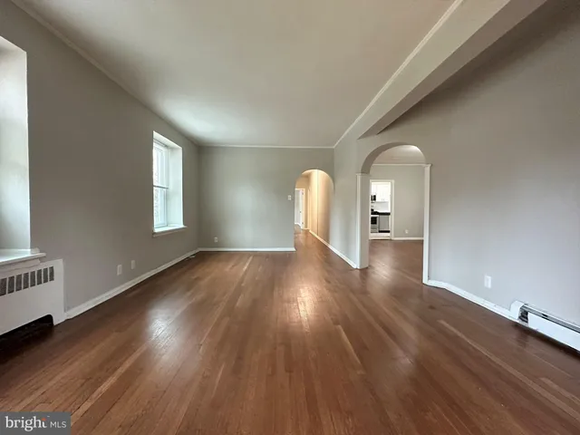 a view of empty room with window and wooden floor