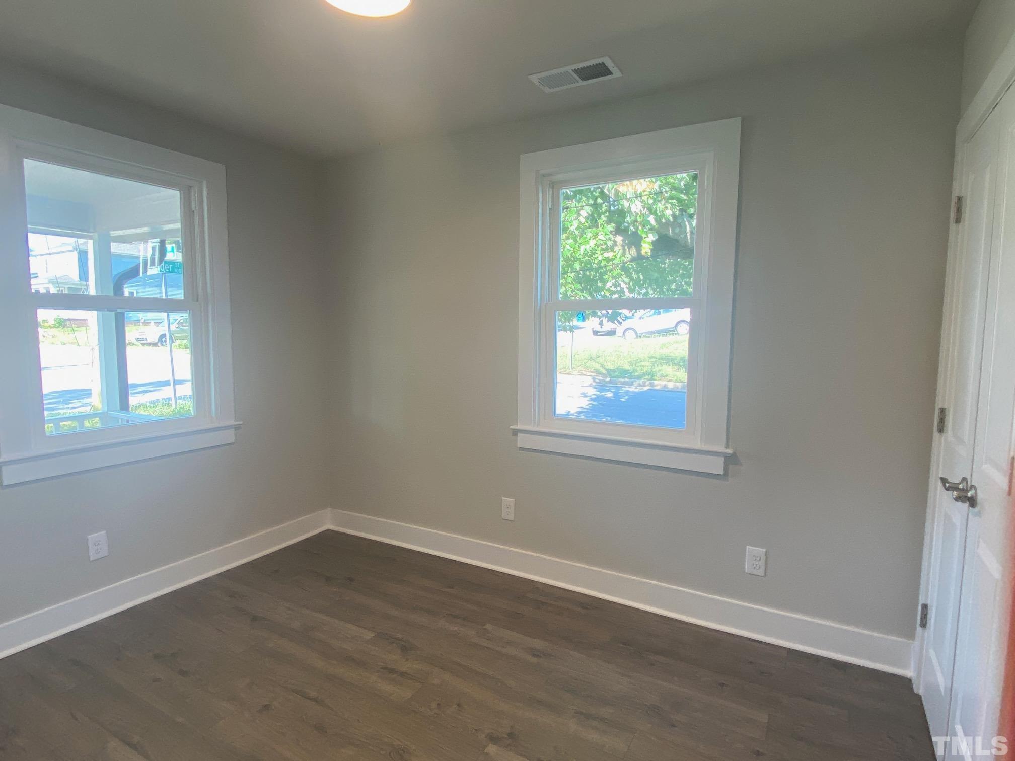 1501 Pender Street Raleigh, NC 27610 - Photo 4 of 8 an empty room with wooden floor and windows