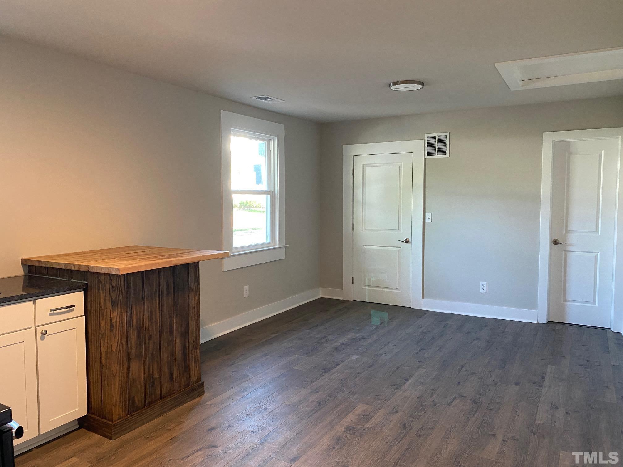 1501 Pender Street Raleigh, NC 27610 - Photo 6 of 8 an empty room with wooden floor and windows