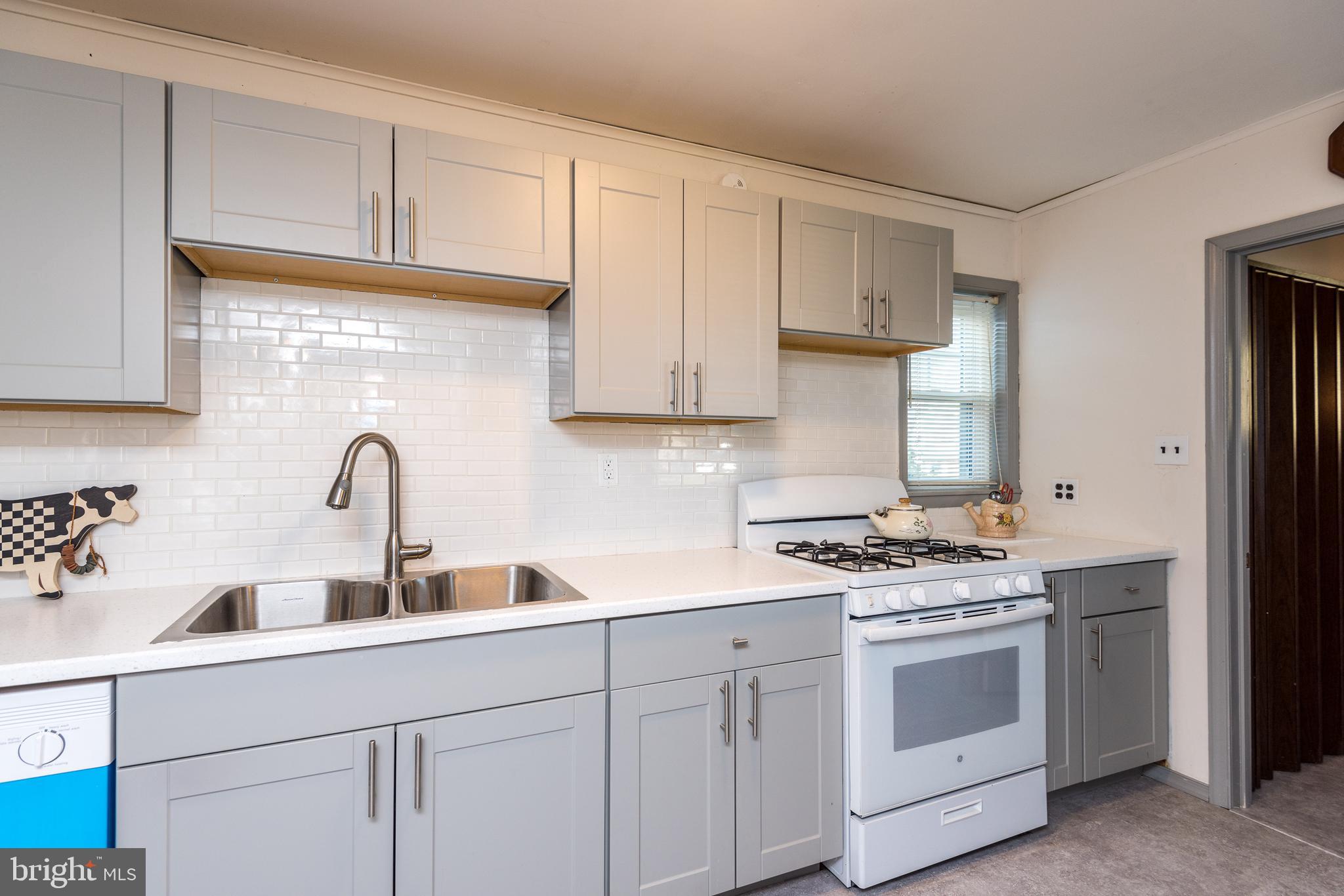 1228 Cambridge Road Warminster, PA 18974 - Photo 7 of 23 a kitchen with white cabinets and appliances