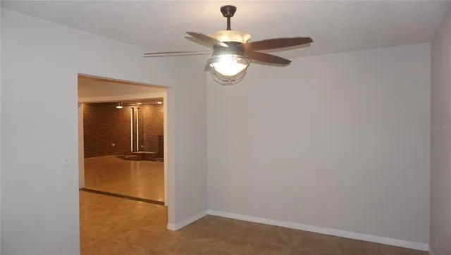 a view of an empty room with closet and a chandelier fan