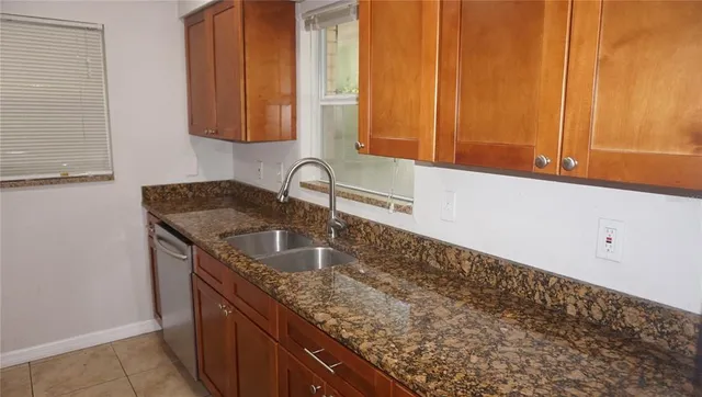 a kitchen with granite countertop a sink and a stove