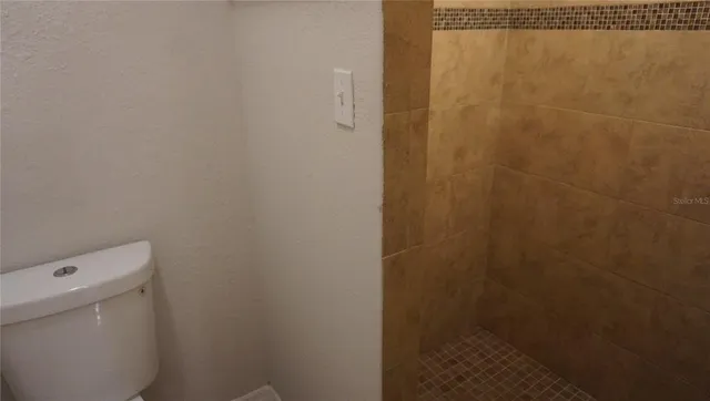 a bathroom with a white toilet and a shower