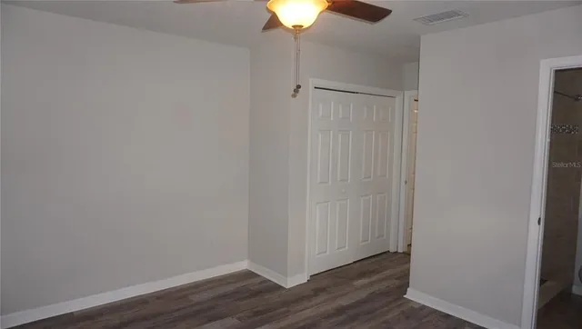 a view of an empty room with wooden floor
