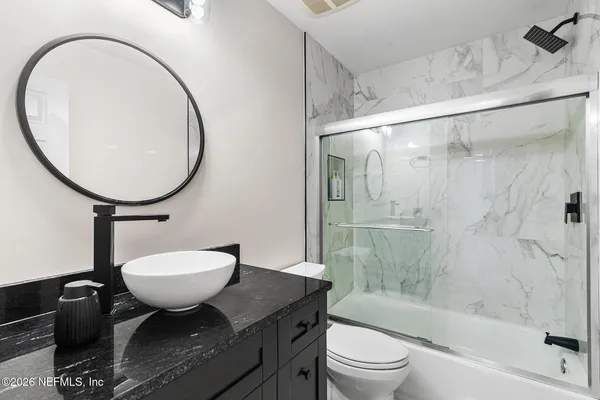 a bathroom with a sink toilet a mirror and shower