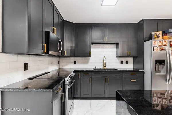 a kitchen with stainless steel appliances granite countertop a sink and a stove