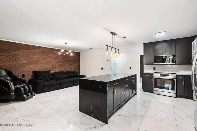 a large kitchen with stainless steel appliances kitchen island granite countertop a stove top oven a sink dishwasher and a refrigerator