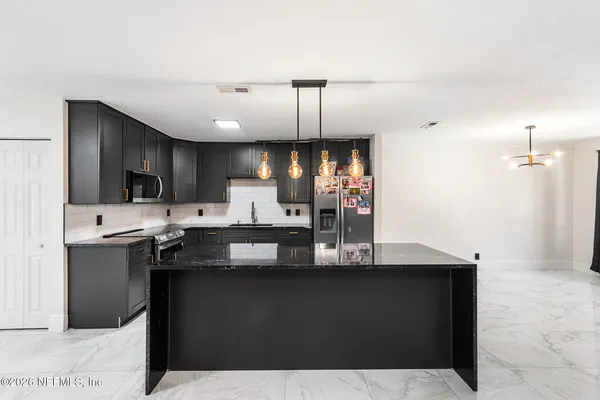 a kitchen with kitchen island a sink stainless steel appliances and cabinets