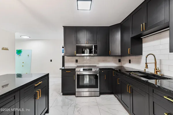 a kitchen with stainless steel appliances granite countertop a sink and a stove