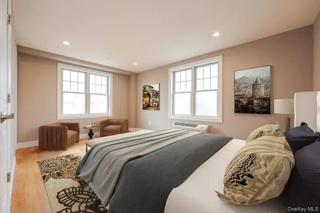 a spacious bedroom with a bed and wooden floor