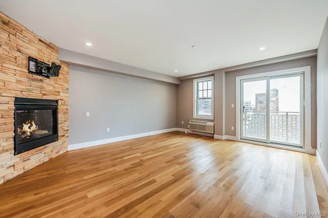 a view of an empty room with a fireplace and a window