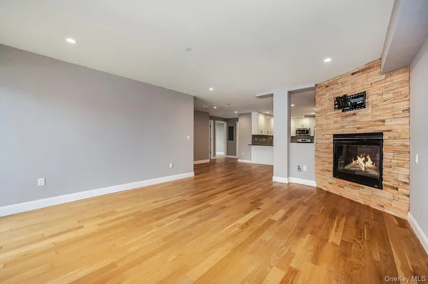 a view of a livingroom with wooden floor and a fireplace