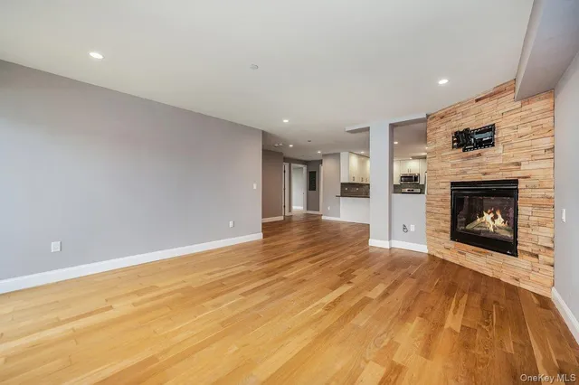 a view of a livingroom with wooden floor and a fireplace