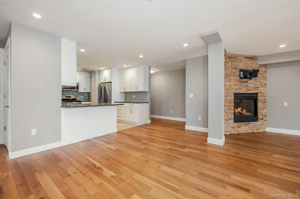 a view of kitchen with kitchen island wooden floor center island and stainless steel appliances