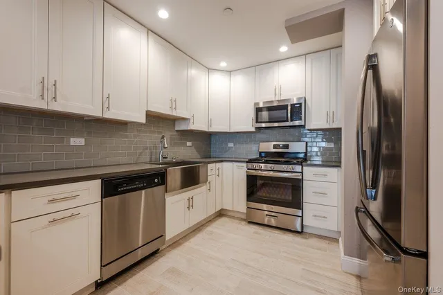 a kitchen with granite countertop a refrigerator and a stove top oven