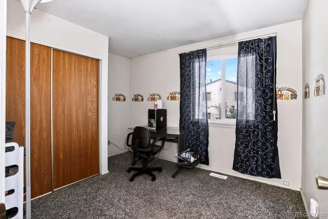 a view of a hallway with workspace and a couch
