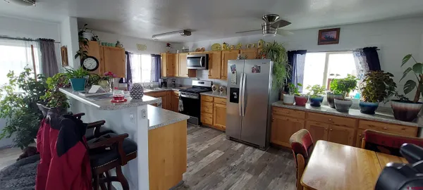 a kitchen with stainless steel appliances granite countertop sink stove refrigerator dining table and chairs