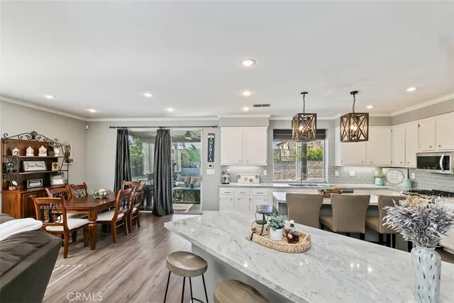 a kitchen with a dining table chairs stove and white cabinets