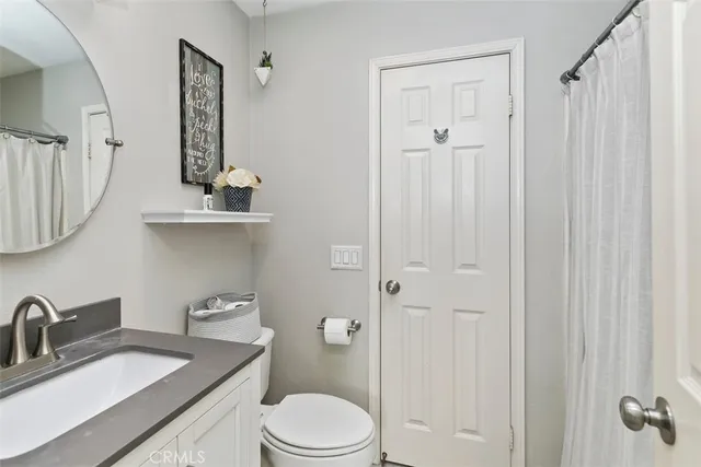 a bathroom with a granite countertop sink a toilet and shower