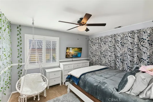 a bedroom with a bed and a chair with the potted plant