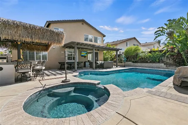 a view of a house with swimming pool and sitting area