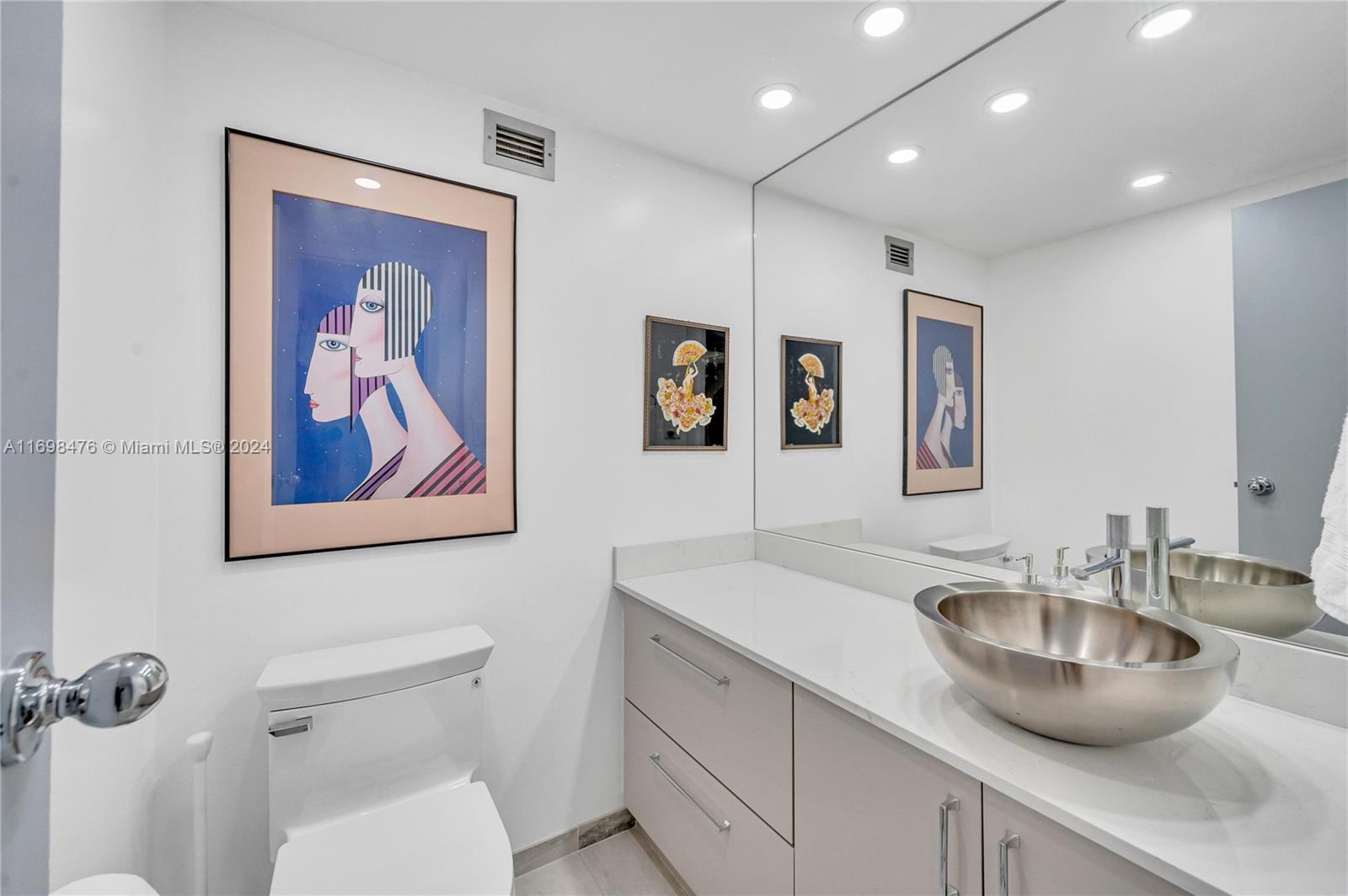 4101 Pine Tree Drive, Unit 1702 Miami Beach, FL 33140 - Photo 25 of 51 a bathroom with a toilet a sink and mirror